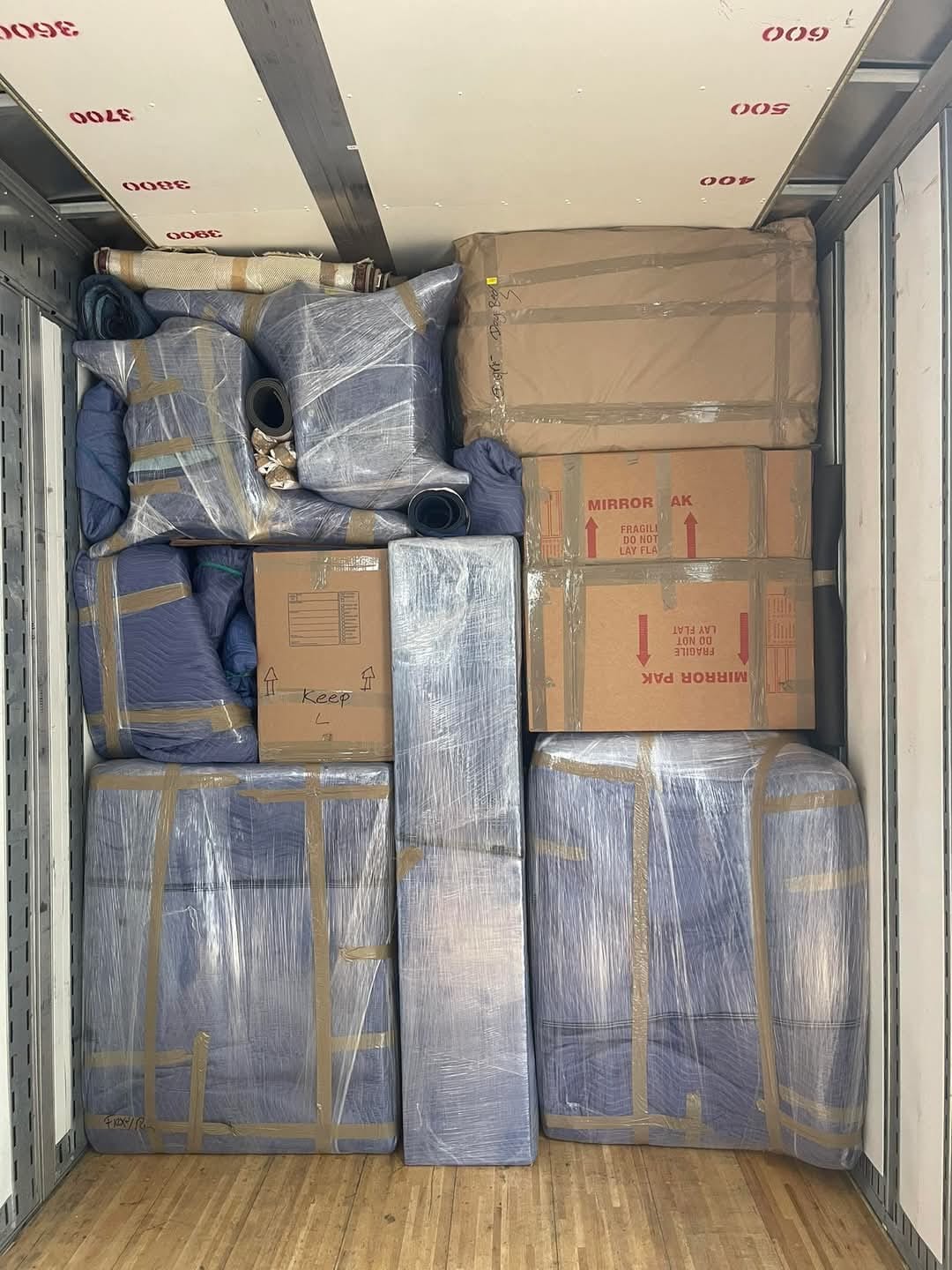 Furniture and boxes wrapped and secured inside a moving truck
